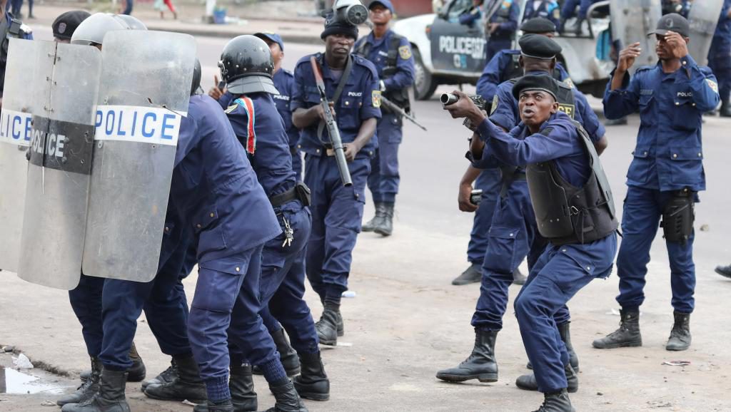 Des policiers réagissant à un jet de pierre depuis le site de la cathédrale Notre Dame à Kinshasa, en RDC ce 25 février 2018. / Photo : REUTERS/Goran Tomasevic
