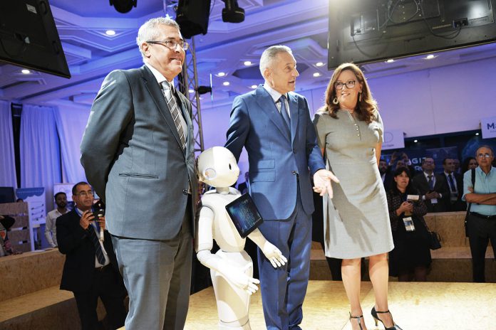 Rabat, Maroc. 04 octobre 2018. Le ministre en charge du numérique, Moulay Hafid Elalamy, engage une conversation avec le robot Pepper. Avec à ses côtés, Mme Saloua de l'APEBI. Photo LesEco.ma Maroc : le robot Pepper, attraction principale du salon AITEX 2018 à Rabat