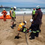 Workers install the 2Africa undersea cable on the beach in Amanzimtoti